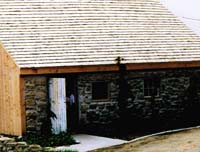 We made a lean-too off of a barn roofed with cedar shakes and front wall made with cobblestone.